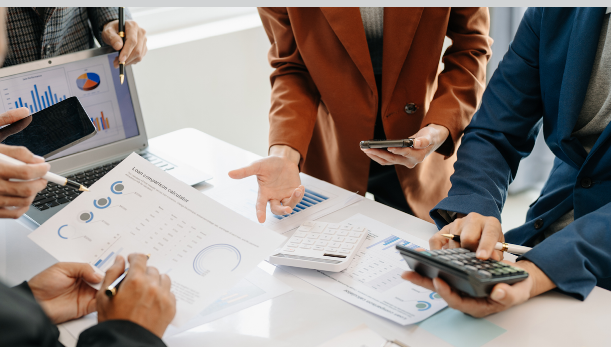 Businessman and team analyzing financial statement Finance task. with smart phone and laptop and tablet. Wealth management concept in office 
